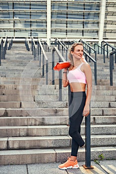 Challenging myself. Full-length of happy woman in sports clothing holding her leg prosthesis and smiling while standing