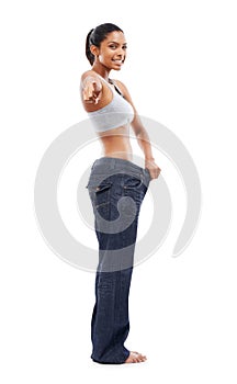 Challenging you to lose the flab. A gorgeous young woman in an oversized pair of pants pointing at you.