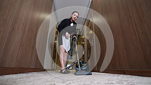 Chambermaid vacuuming in hotel corridor