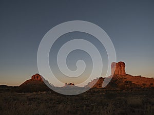 Chambers Pillar Central Australia at sunset with blue sky