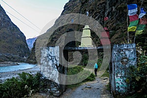 Chame -A girl crossing a gate on a hike in Himalayas