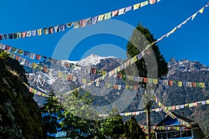 Chame - Prayer flags waving above Himalayan peaks