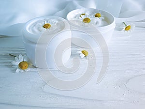 Chamomile flower, cosmetic beautiful freshness cream facial on a white wooden background