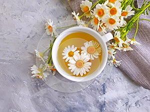 Chamomile flower tea morning on concrete background herbal