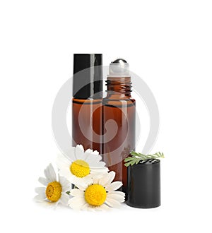 Chamomile flowers and cosmetic bottles of essential oil