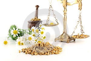 Chamomile flowers with mortar and scales