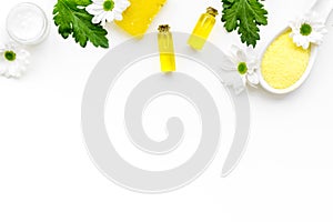 Chamomile spa cosmetics with natural herbal ingredients. Chamomile spa salt, soap, oil and cream on white background top