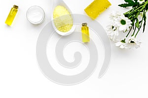 Chamomile spa cosmetics with natural herbal ingredients. Chamomile spa salt, soap, oil and cream on white background top