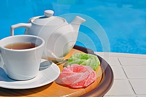 Chamomile tea in a cup in front of the pool