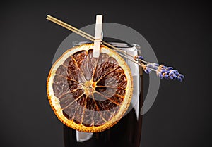 Champagne based black cocktail decorated with lavender flowers and dried orange. Selective focus. Shallow depth of field