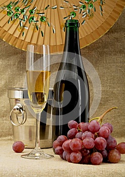 Champagne bottle, bucket, goblet and grapes