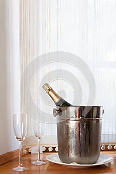 Champagne bottle in bucket and two glasses