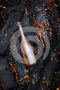 Champagne bottle in hot embers background