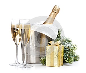 Champagne bottle in ice bucket, two empty glasses and christmas