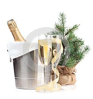 Champagne bottle in ice bucket, two glasses and christmas decor