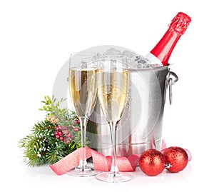 Champagne bottle in ice bucket, two glasses and christmas decor