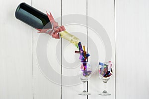 Champagne bottle pours streamers into two glasses