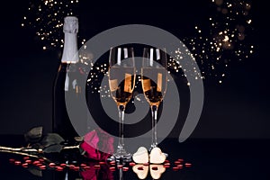 Champagne bottle with two wine glasses and red rose