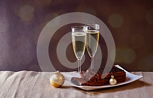 Champagne, chocolate cake  and christmas decorations on dark background. Selective focus. View with copy space