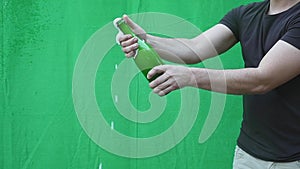 Champagne explosion. Man hand opening champagne bottle closeup. Sparkling Wine over Holiday Bokeh Blinking Background