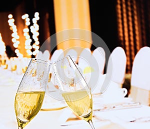 Champagne flutes with golden bubbles on christmas table decoration background