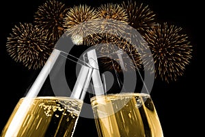 Champagne flutes with golden bubbles make cheers with fireworks sparkle and black background