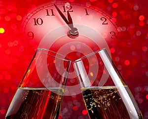 Champagne flutes with golden bubbles on red light bokeh background