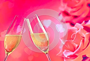 Champagne flutes with golden bubbles on roses flowers background