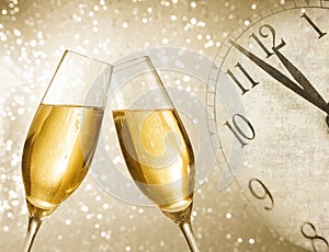 Champagne flutes with golden bubbles on silver light bokeh background