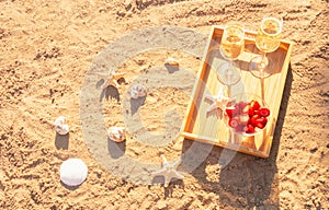 Champagne, fresh strawberry, starfishes and seashells on sand beach. Top view