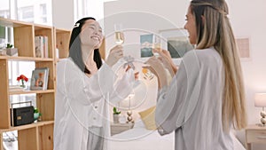 Champagne, friends and toast with women dance in celebration of good news in their home together. Happy, relax and