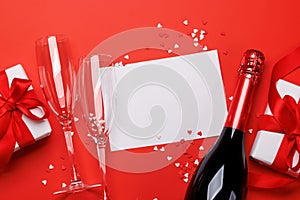 Champagne and gift: Celebratory duo on a red background with text space