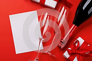 Champagne and gift: Celebratory duo on a red background with text space