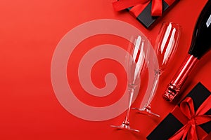 Champagne and gift: Celebratory duo on a red background with text space