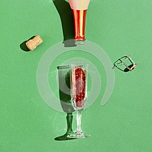 Champagne glass and bottle with bright red sequins, sparkling festive drink. New year or Christmas party celebration.