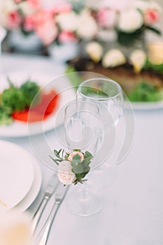 The champagne glass is decorated with little white rose.