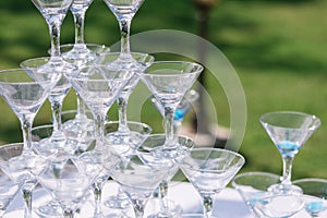 Champagne glass pyramid. Pyramid of glasses of wine, champagne, tower of champagne`s glass in wedding reception party. Summertime