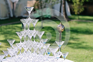 Champagne glass pyramid. Pyramid of glasses of wine, champagne, tower of champagne`s glass in wedding reception party. Summertime