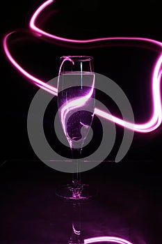 The champagne or champagne glass surrounded by pink lines of light photo