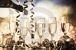 champagne glasses against holiday lights ready for New Year& x27;s eve party