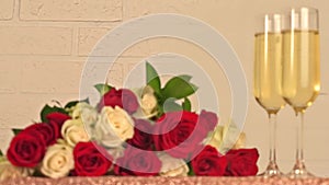 Champagne glasses and bouquet of red, white roses on white background