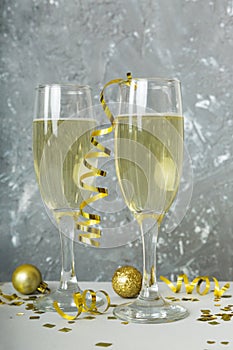 Champagne glasses and christmas decor on colored holiday background. Flat lay New Year decorations