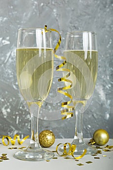 Champagne glasses and christmas decor on colored holiday background. Flat lay New Year decorations