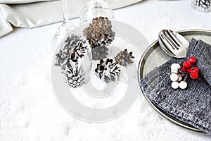 Champagne glasses with decorated pine cones Table Setting on white snow. Christmas decorations. Happy new year. Copy space.