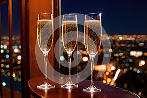 Champagne glasses flutes on balcony overlooking city, festive special occasion