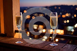 Champagne glasses flutes on balcony overlooking city, festive special occasion