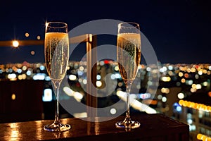 Champagne glasses flutes on balcony overlooking city, festive special occasion