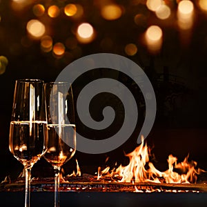 Champagne glasses in front of a log fire