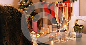 Champagne glasses and gifts box on table