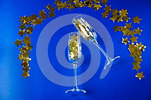 Champagne glasses with gold stars on a blue background